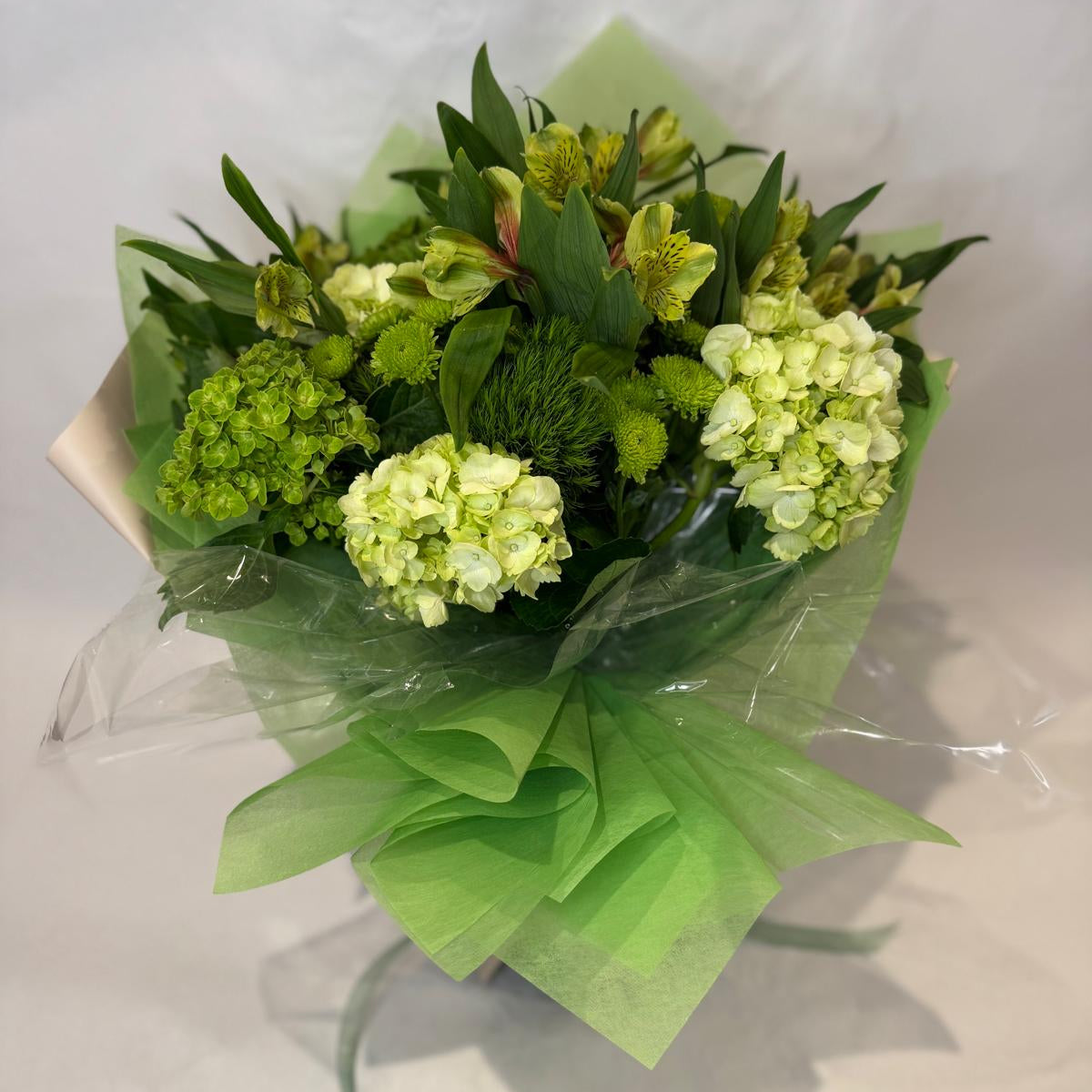 A vibrant green bouquet featuring soft lime and chartreuse blooms, inspired by the peridot birthstone and symbolizing growth and vitality.