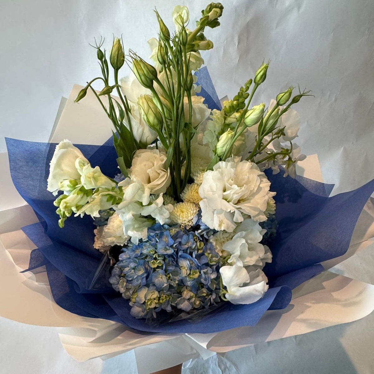 Soft blue and white baby shower bouquet with a fresh and cheerful look, perfect for welcoming a baby boy.
