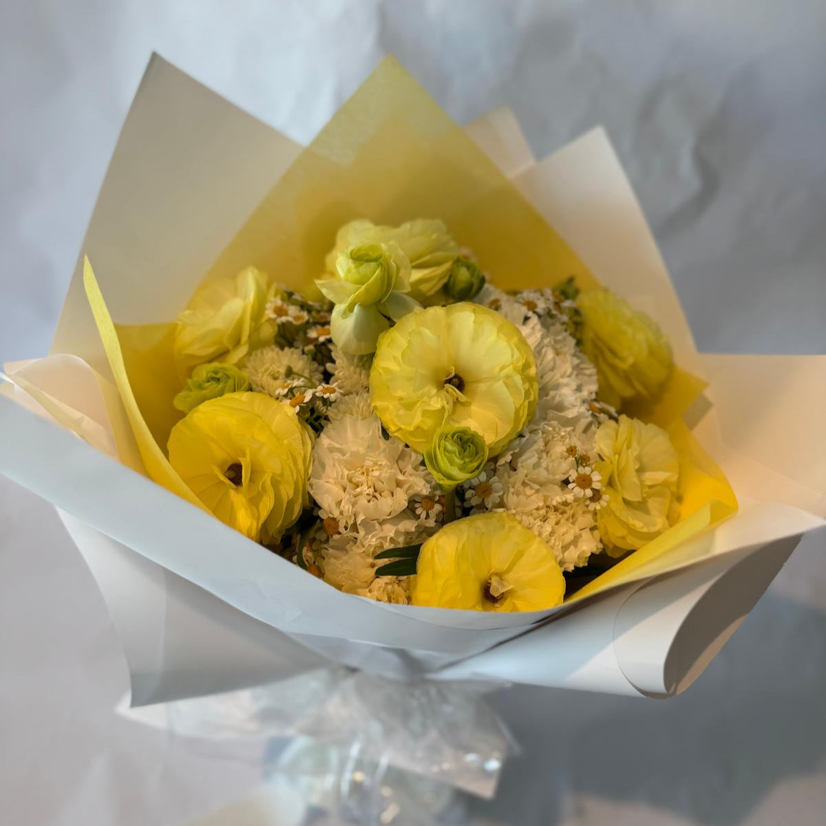 Gender-neutral baby shower bouquet in soft cream, white, and pale yellow tones with a delicate and serene appearance.