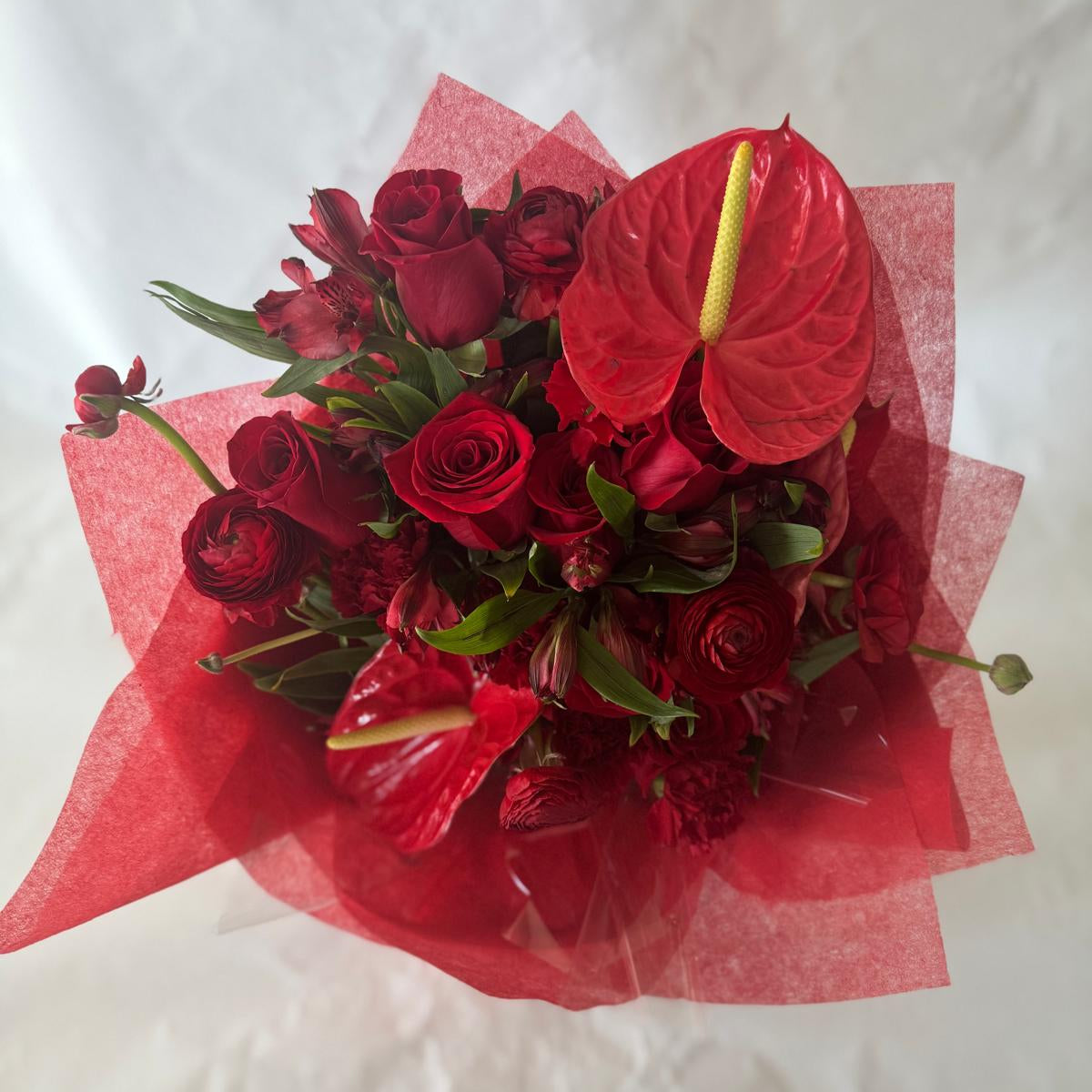 July Ruby bouquet from the Floral Gem Collection featuring an elegant arrangement of all-red blooms. A striking, floral-only design inspired by the deep, passionate tones of the ruby birthstone.