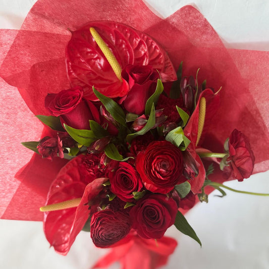 July Ruby bouquet from the Floral Gem Collection featuring an elegant arrangement of all-red blooms. A striking, floral-only design inspired by the deep, passionate tones of the ruby birthstone.