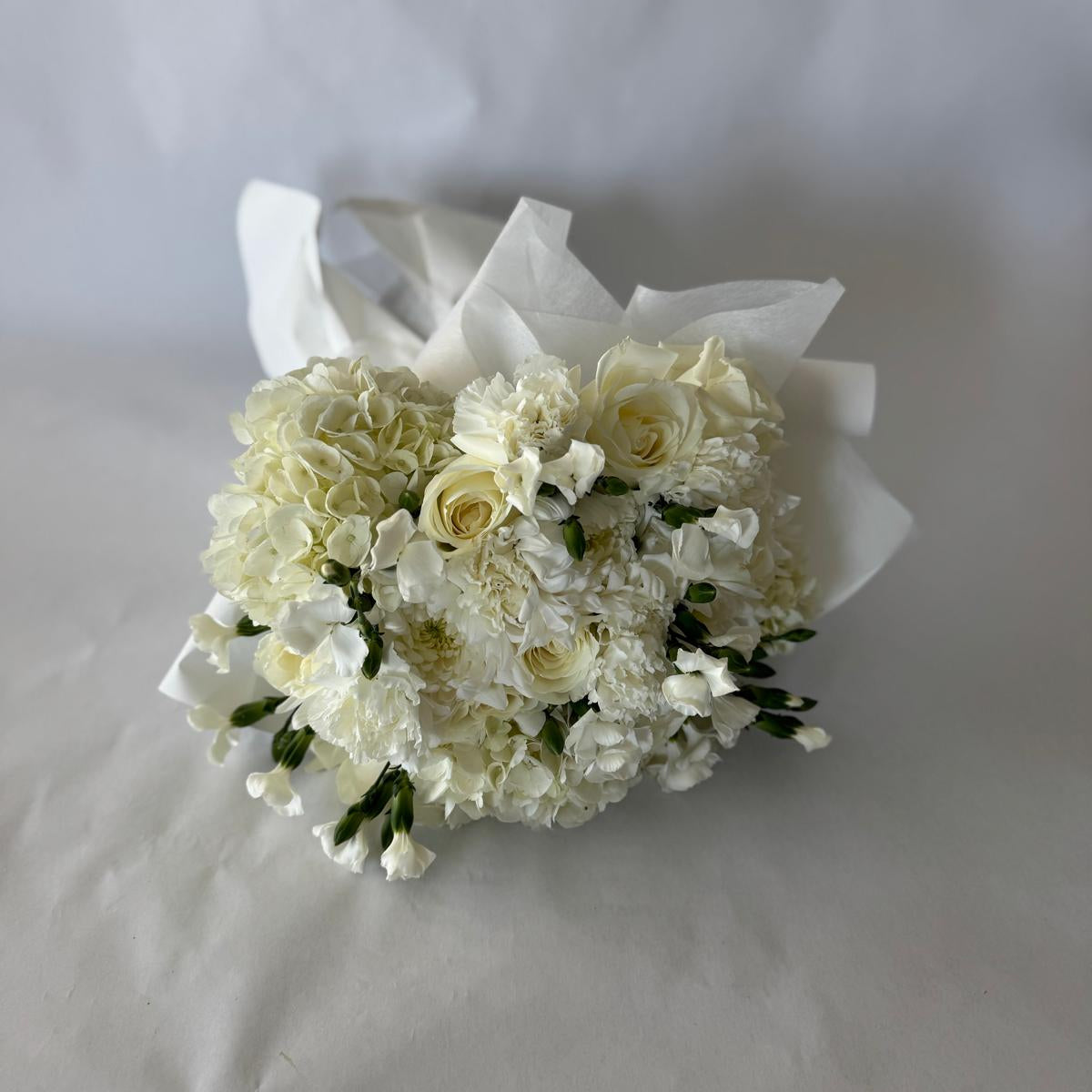 Floral-only bouquet in soft ivory tones with roses, carnations, and seasonal filler blooms, inspired by the June birthstone