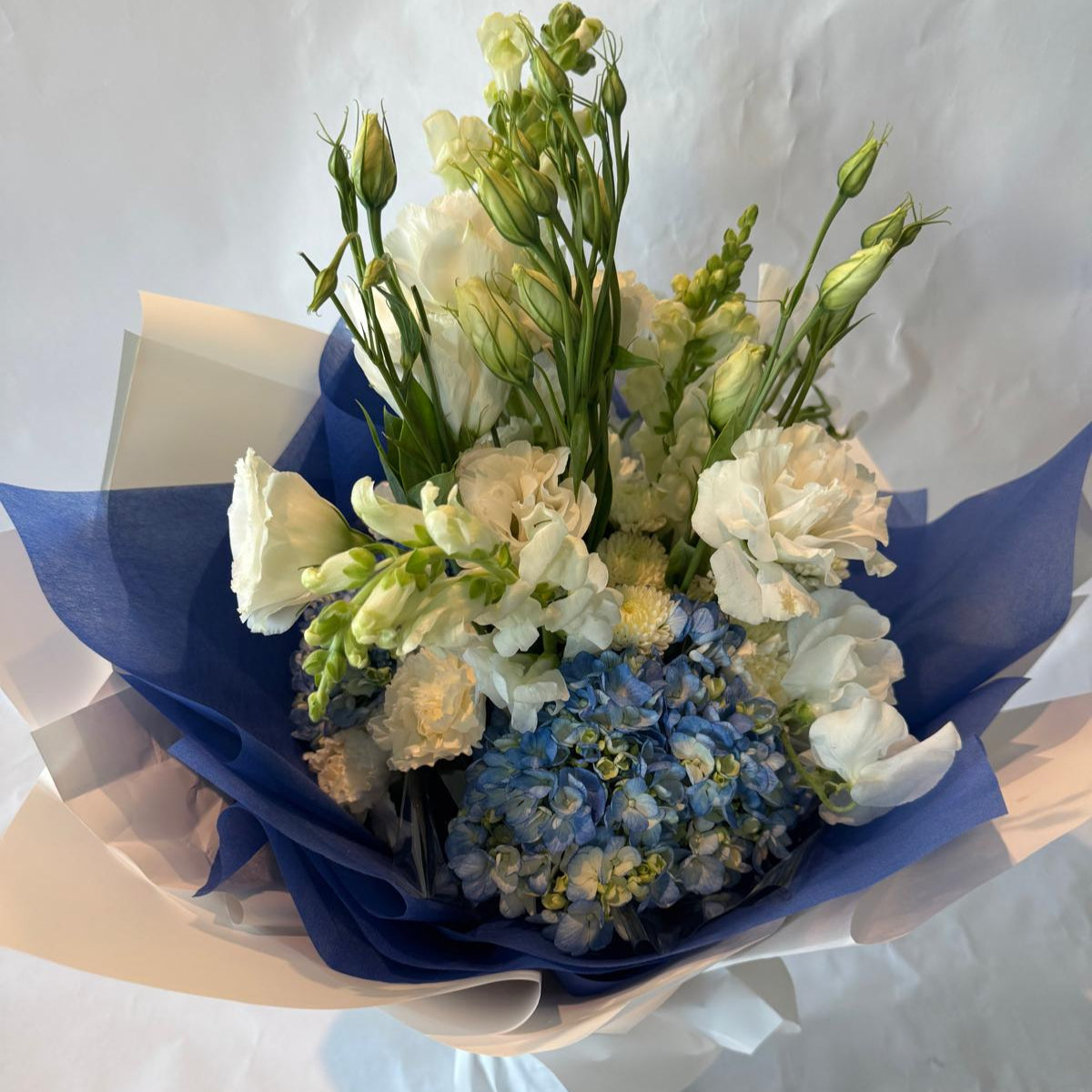 Soft blue and white baby shower bouquet with a fresh and cheerful look, perfect for welcoming a baby boy.