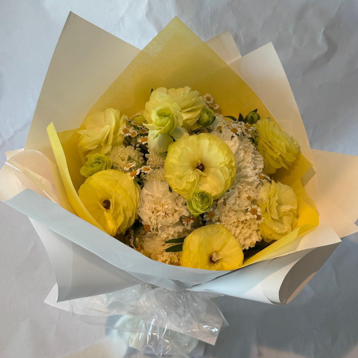 Gender-neutral baby shower bouquet in soft cream, white, and pale yellow tones with a delicate and serene appearance.