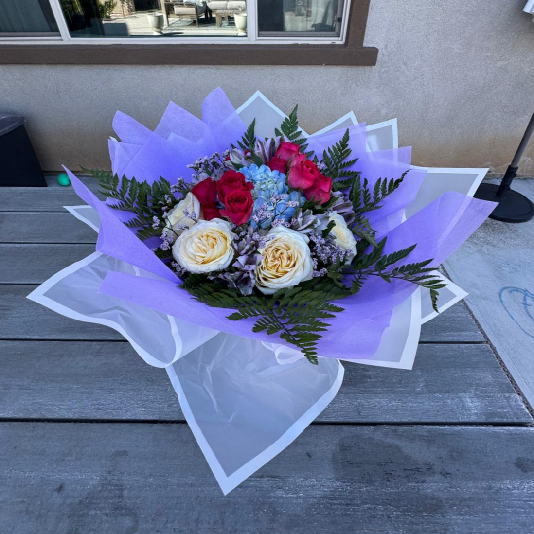 October Radiance bouquet inspired by opal and pink tourmaline, featuring jewel-toned and pastel blooms wrapped in lilac and white for a radiant autumn design.