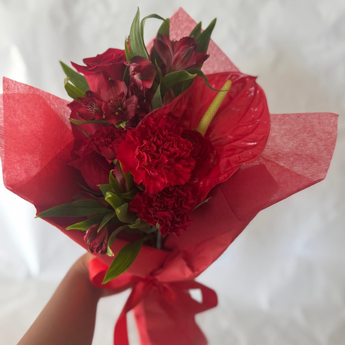 July Ruby bouquet from the Floral Gem Collection featuring an elegant arrangement of all-red blooms. A striking, floral-only design inspired by the deep, passionate tones of the ruby birthstone.