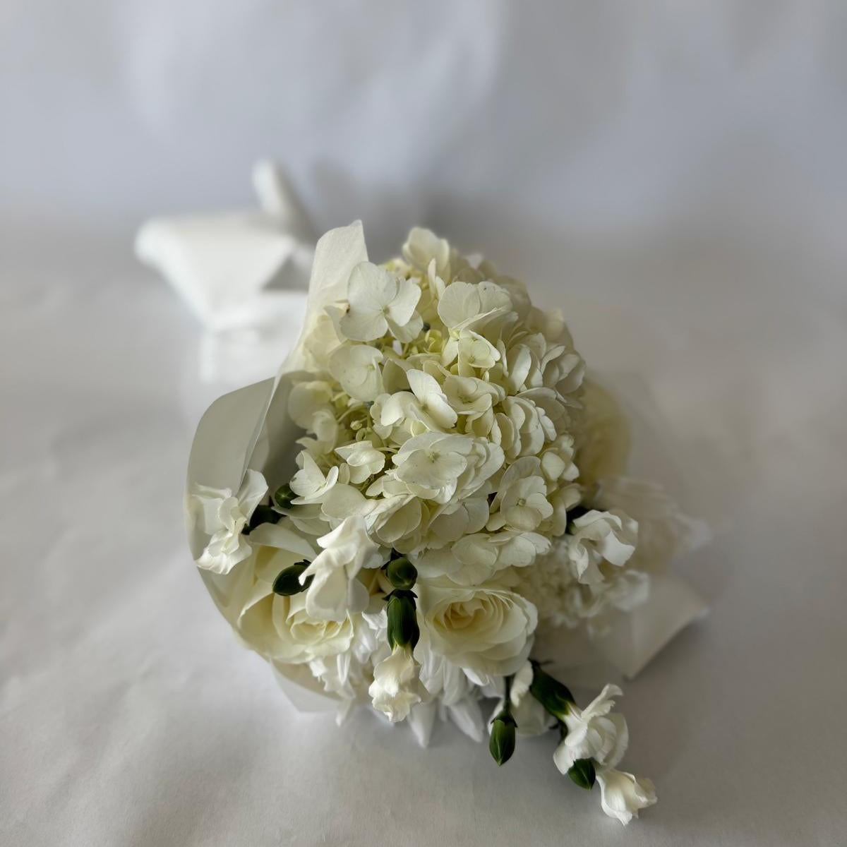 Floral-only bouquet in soft ivory tones with roses, carnations, and seasonal filler blooms, inspired by the June birthstone