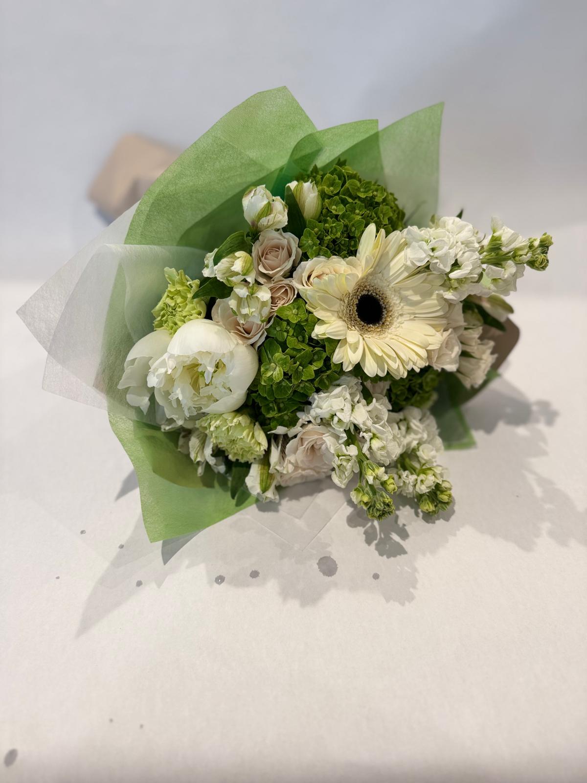 White and green bouquet with soft wrapping and a light, crisp aesthetic.