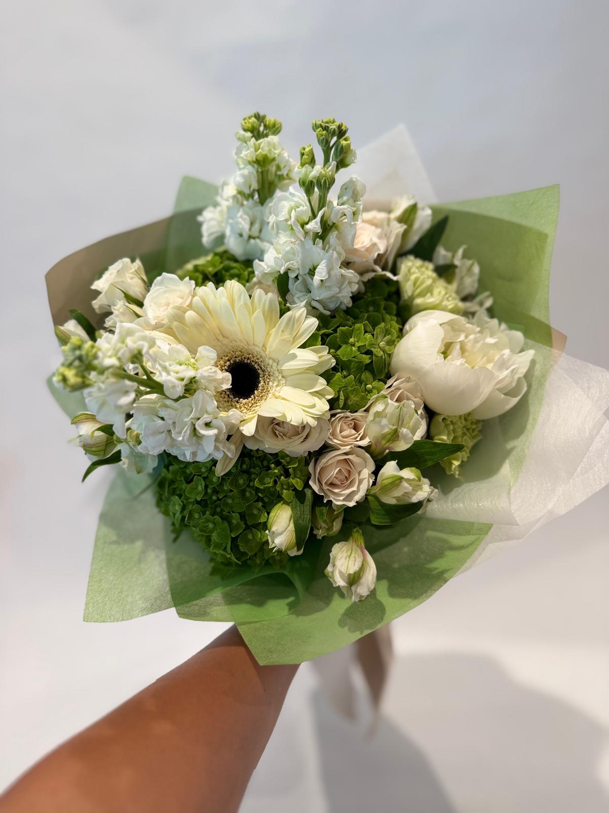 White and green bouquet with soft wrapping and a light, crisp aesthetic.