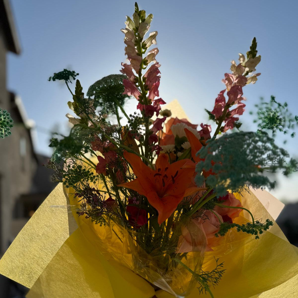 Summer bouquet featuring watermelon pink, apricot, blush, and soft blue blooms arranged in a floral-only style and wrapped in neutral kraft paper – Summer Sorbet 25 by Nai Pascoal Bouquets