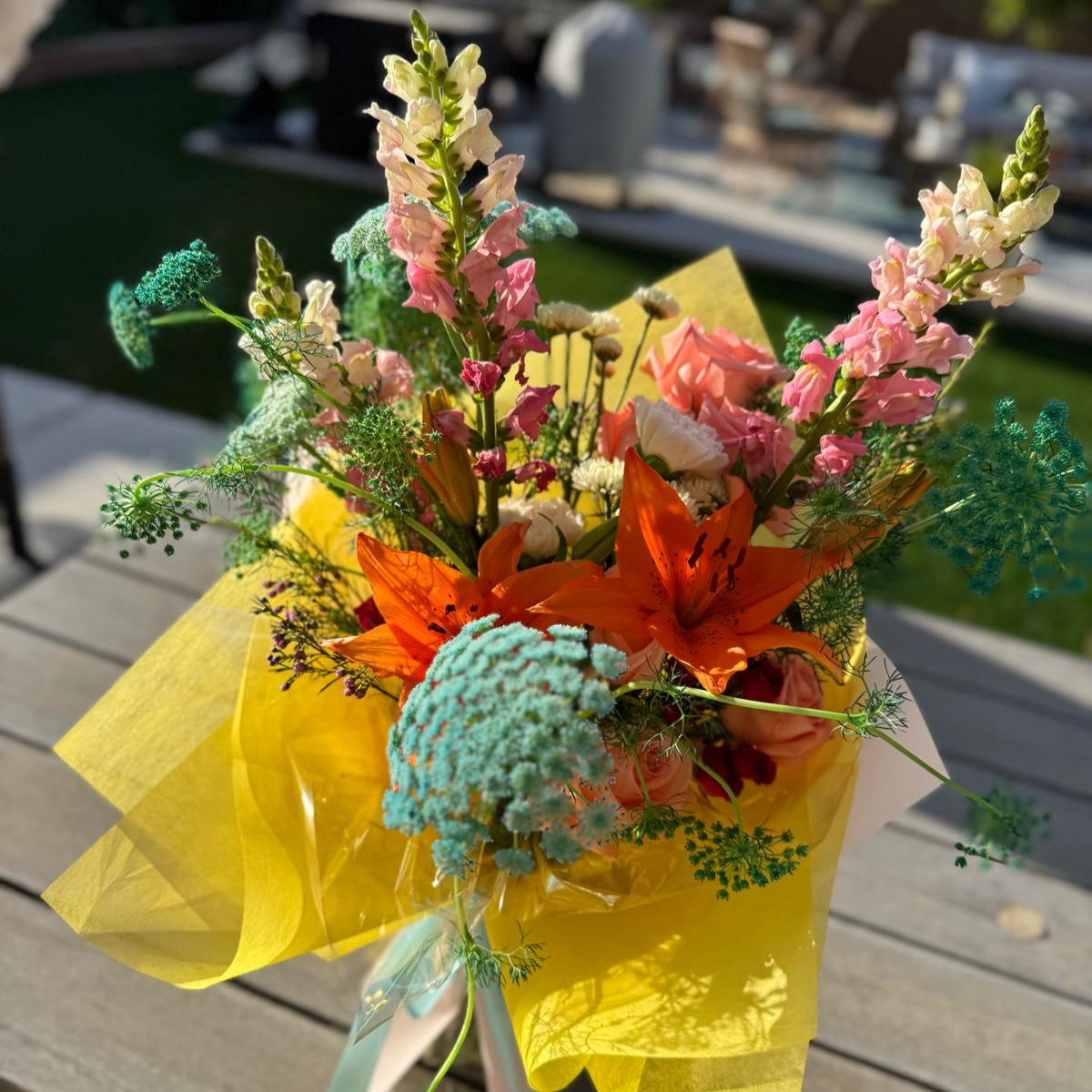 Summer bouquet featuring watermelon pink, apricot, blush, and soft blue blooms arranged in a floral-only style and wrapped in neutral kraft paper – Summer Sorbet 25 by Nai Pascoal Bouquets