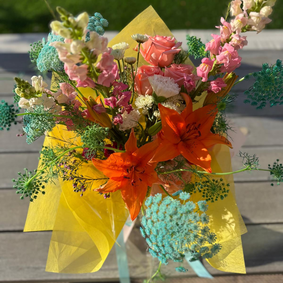 Summer bouquet featuring watermelon pink, apricot, blush, and soft blue blooms arranged in a floral-only style and wrapped in neutral kraft paper – Summer Sorbet 25 by Nai Pascoal Bouquets