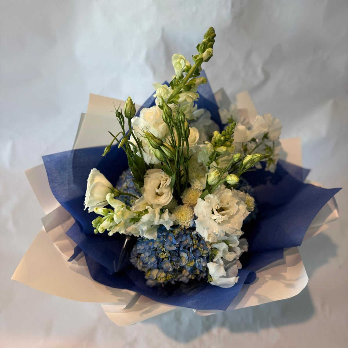 Soft blue and white baby shower bouquet with a fresh and cheerful look, perfect for welcoming a baby boy.