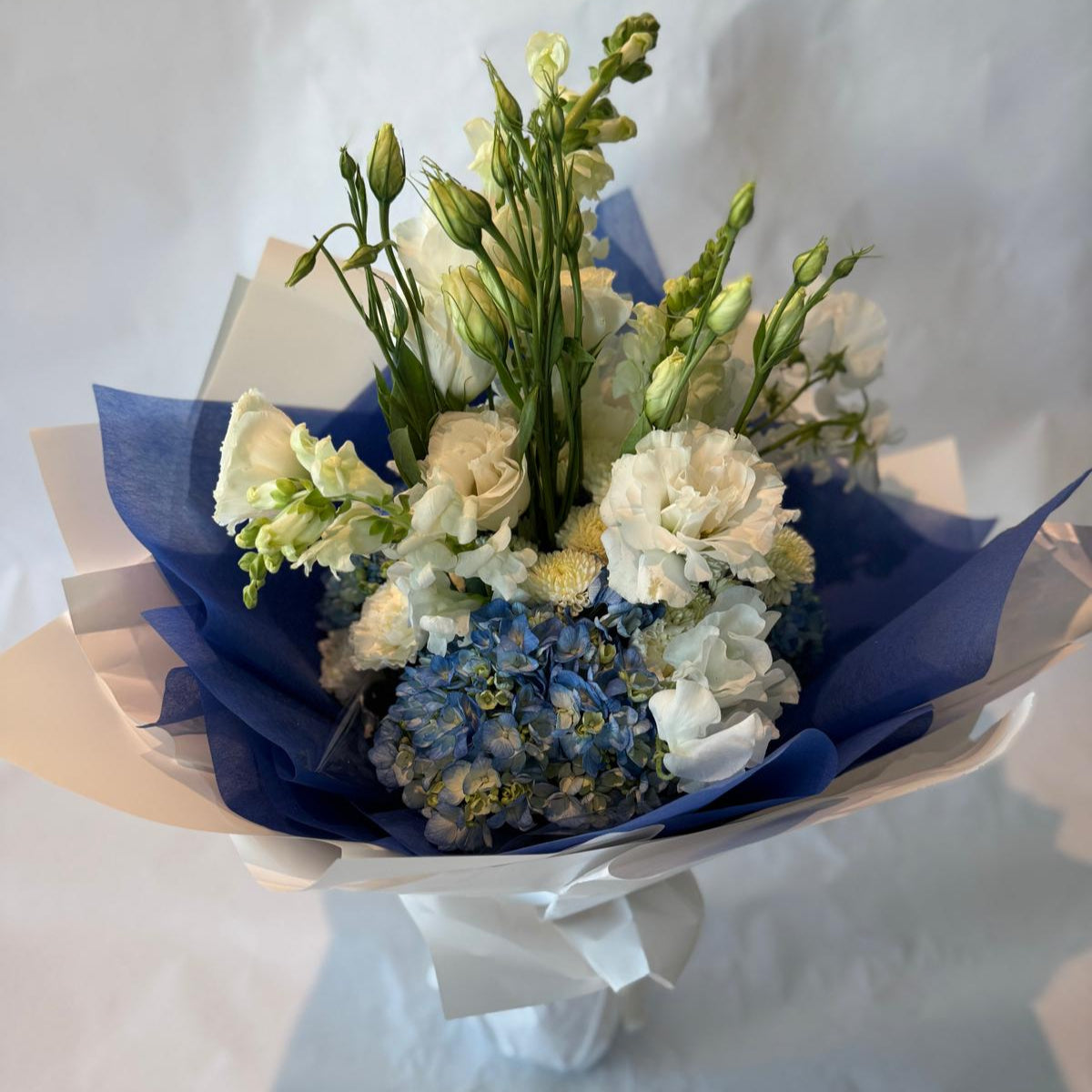 Soft blue and white baby shower bouquet with a fresh and cheerful look, perfect for welcoming a baby boy.