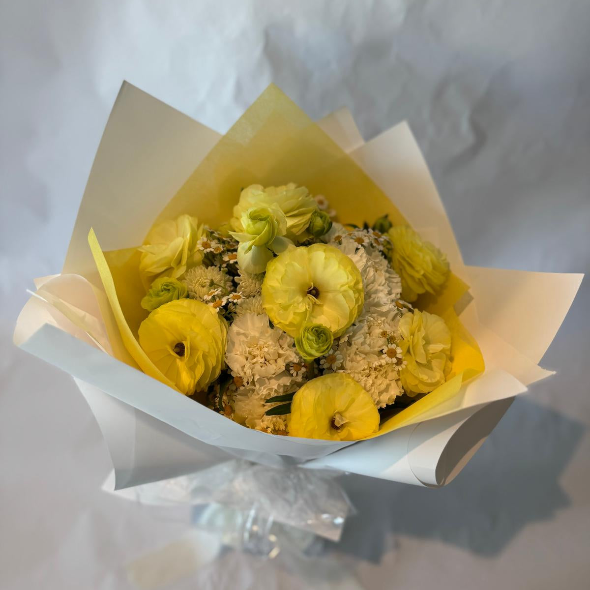 Gender-neutral baby shower bouquet in soft cream, white, and pale yellow tones with a delicate and serene appearance.