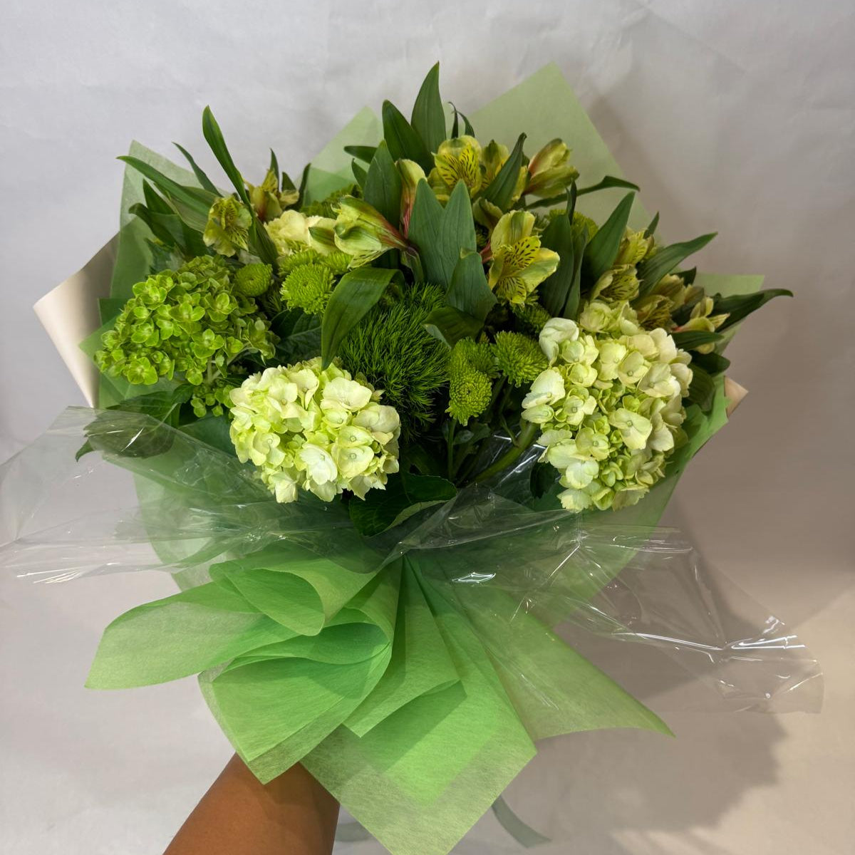 A vibrant green bouquet featuring soft lime and chartreuse blooms, inspired by the peridot birthstone and symbolizing growth and vitality.