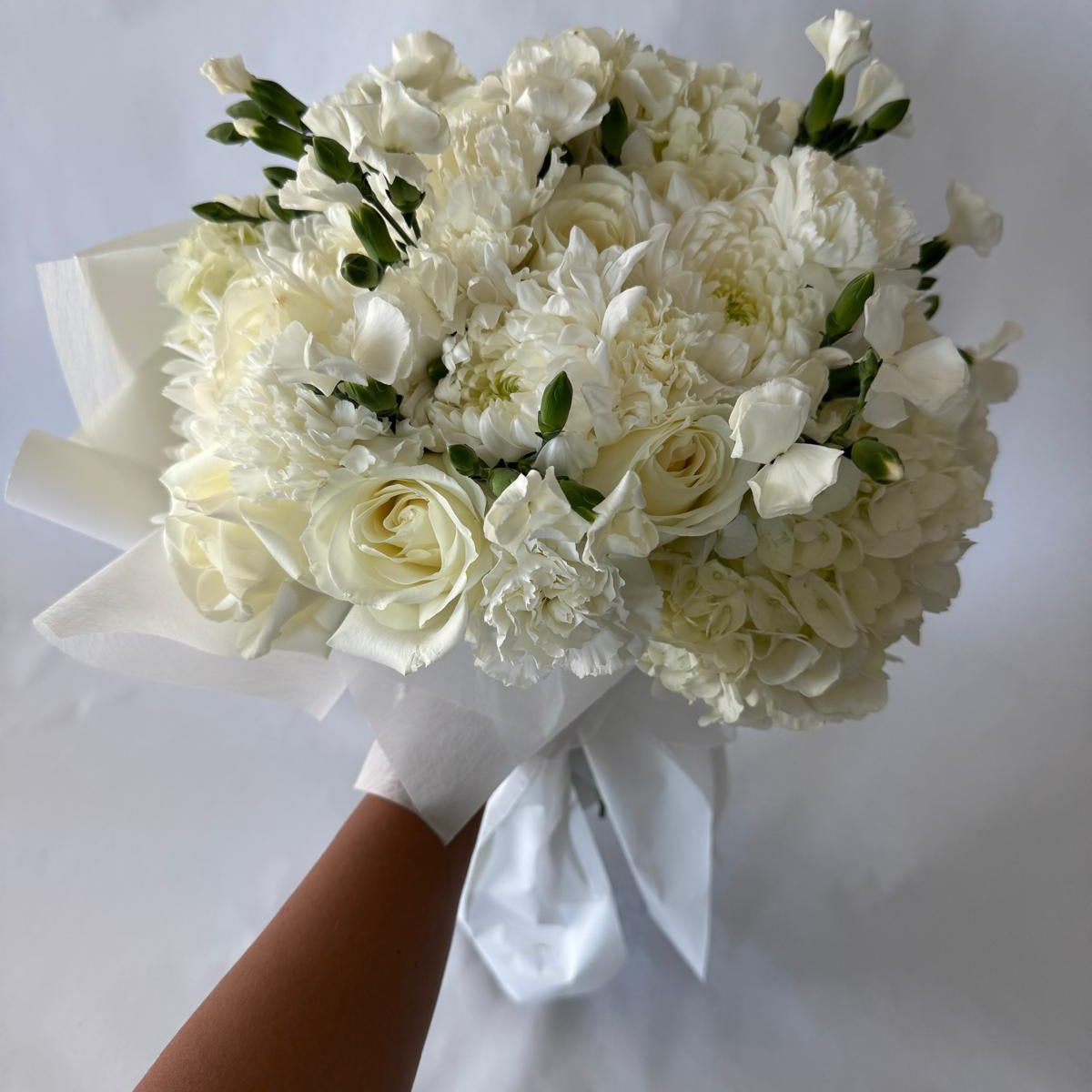 Full and lush floral-only bouquet in soft ivory tones with roses, carnations, and seasonal filler blooms, inspired by the June birthstone