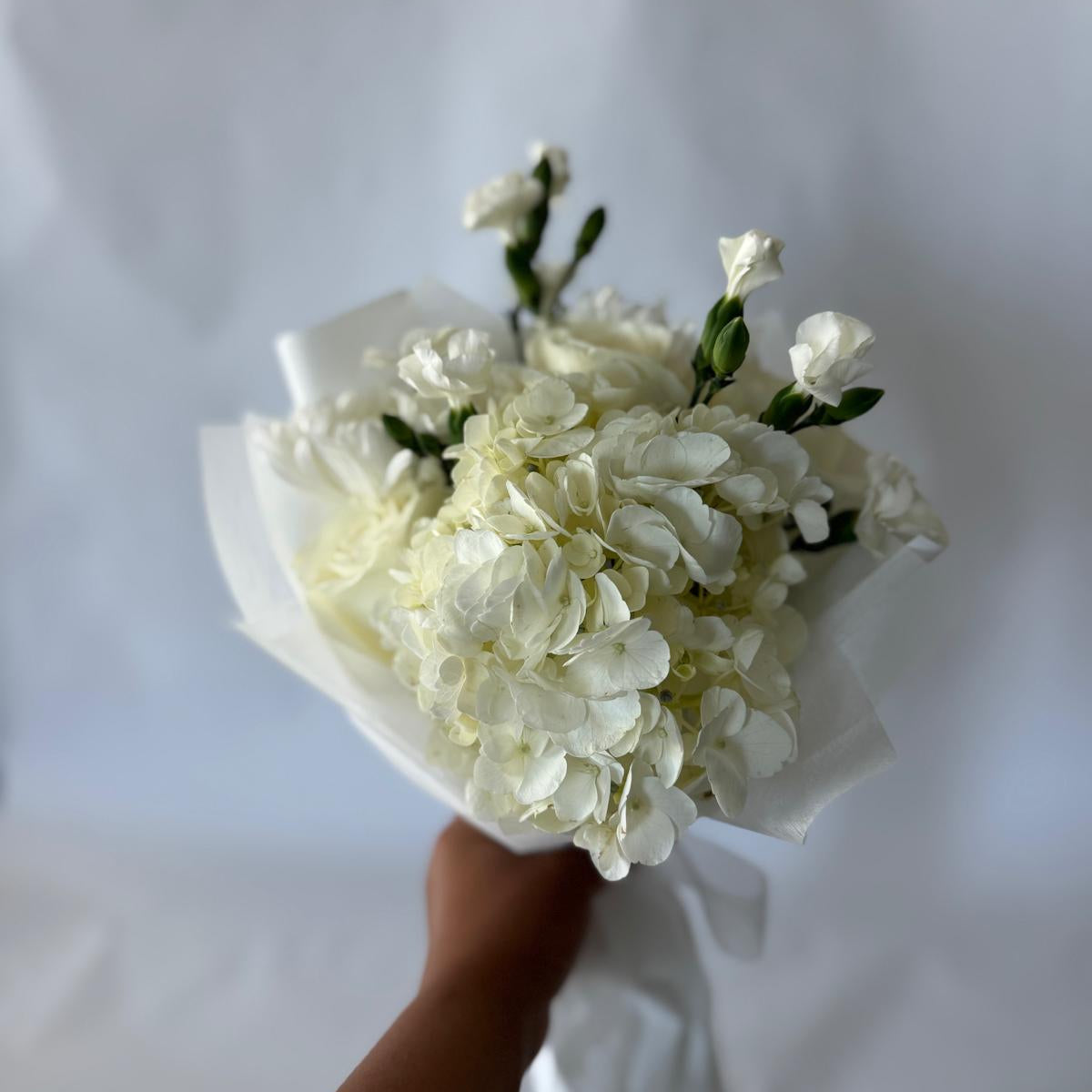 Floral-only bouquet in soft ivory tones with roses, carnations, and seasonal filler blooms, inspired by the June birthstone