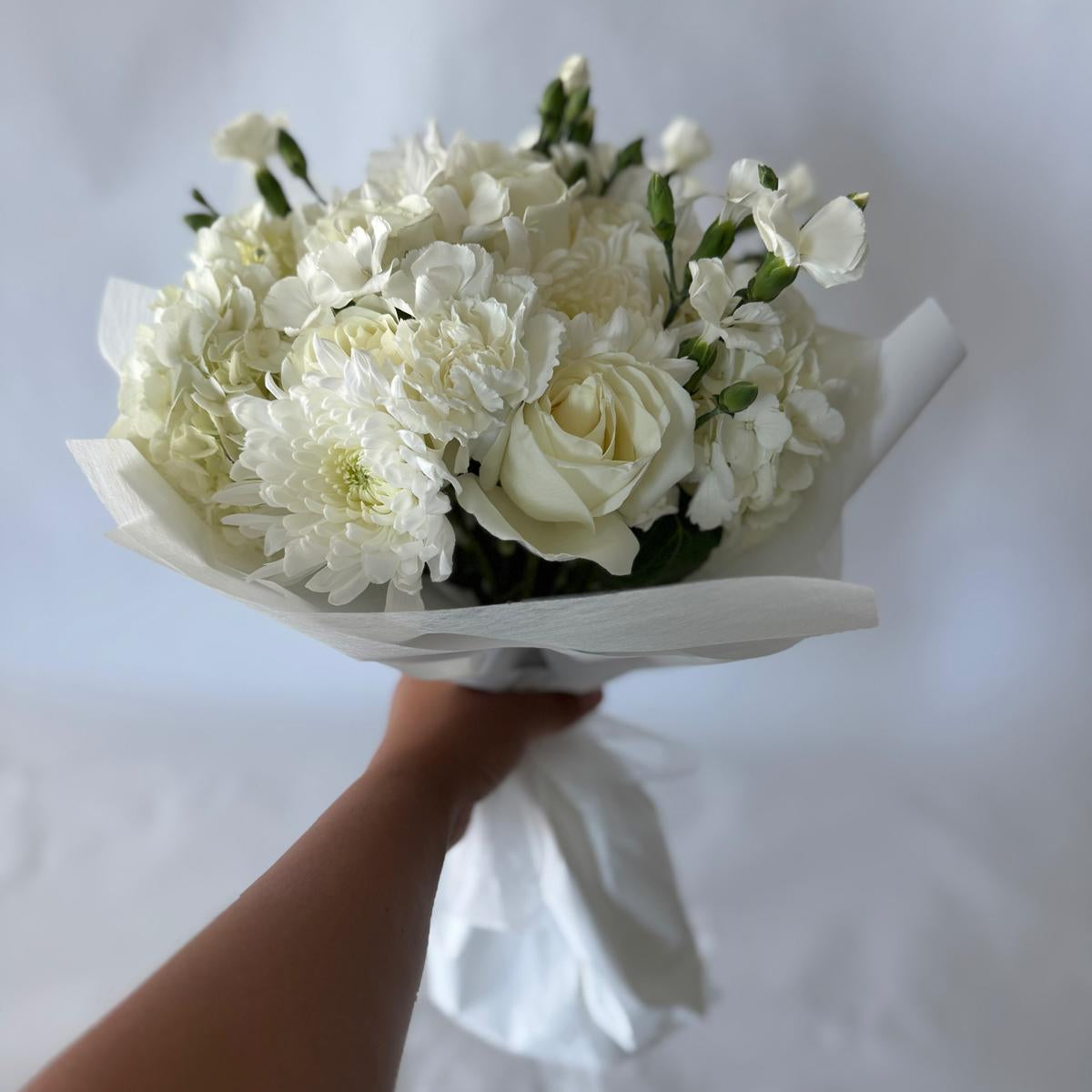 Signature-sized white and ivory bouquet featuring hydrangea and delicate filler flowers, handcrafted in a clean, greenery-free design