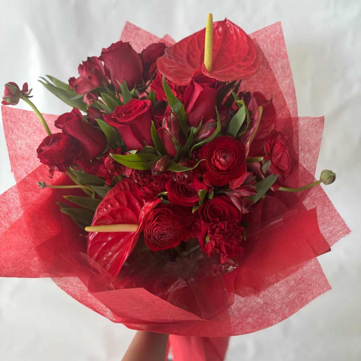 July Ruby bouquet from the Floral Gem Collection featuring an elegant arrangement of all-red blooms. A striking, floral-only design inspired by the deep, passionate tones of the ruby birthstone.