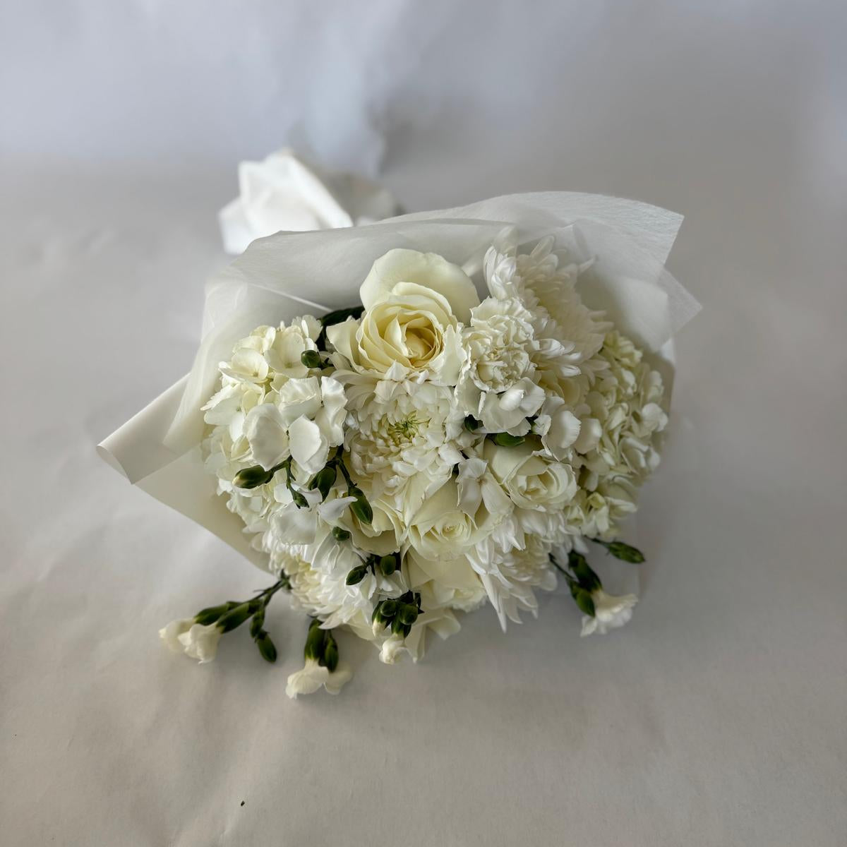 Floral-only bouquet in soft ivory tones with roses, carnations, and seasonal filler blooms, inspired by the June birthstone