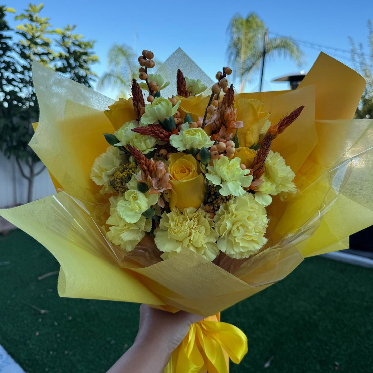 November Glow Bouquet inspired by Citrine & Topaz birthstones, featuring golden yellow roses, amber accents, and autumn textures wrapped in golden paper.