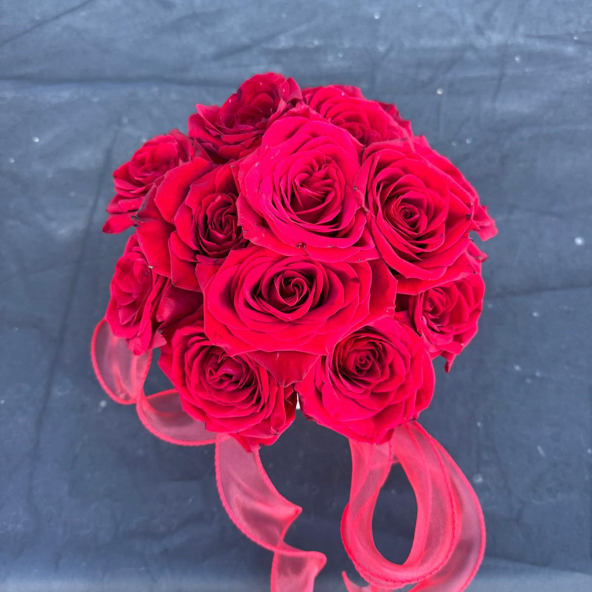 Red rose Valentine’s Day arrangement in a round box with a sheer red ribbon.