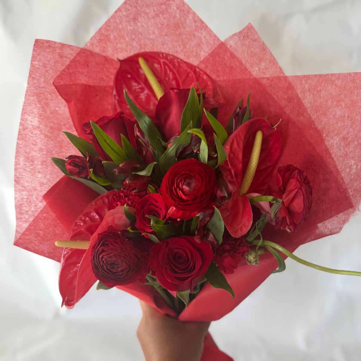 July Ruby bouquet from the Floral Gem Collection featuring an elegant arrangement of all-red blooms. A striking, floral-only design inspired by the deep, passionate tones of the ruby birthstone.