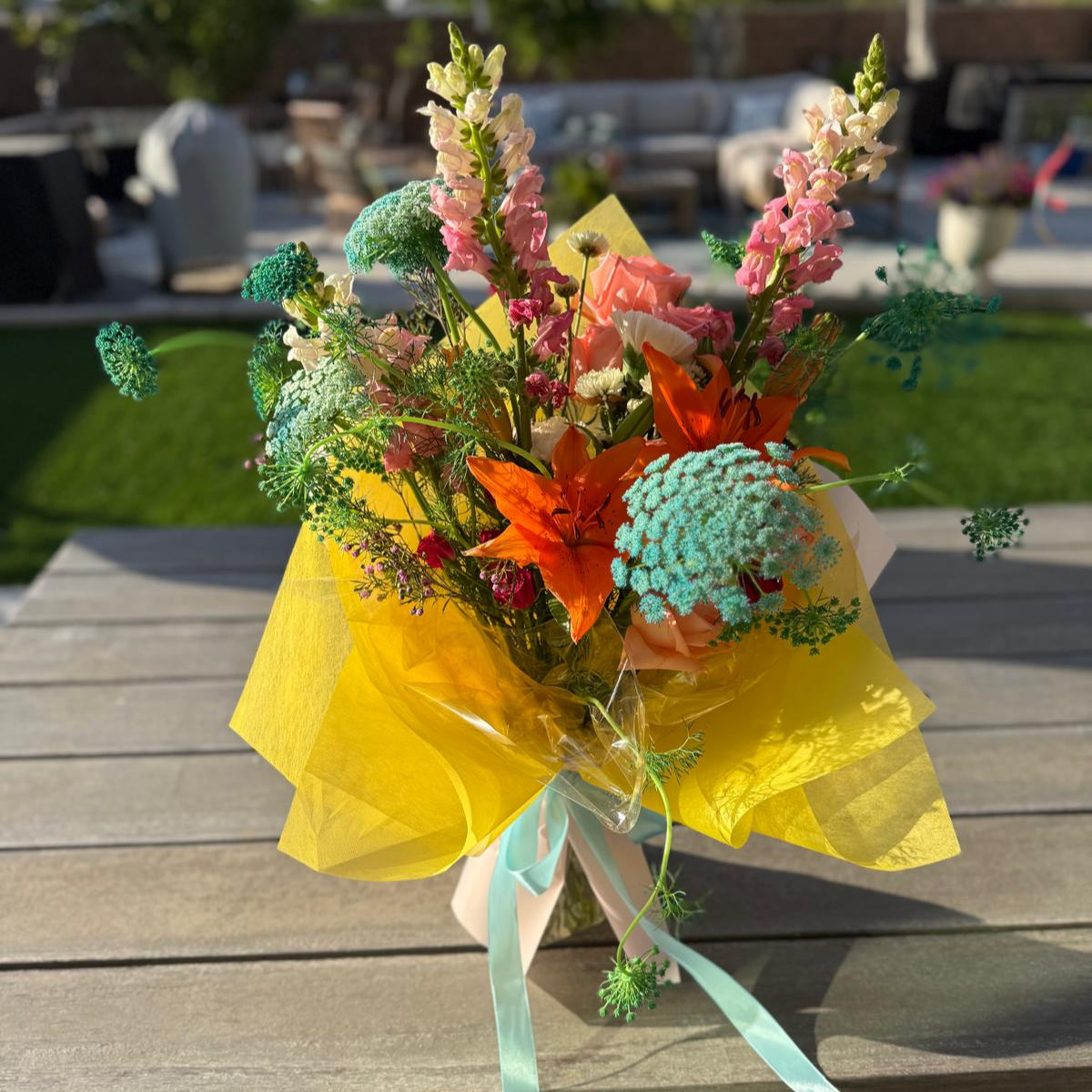 Summer bouquet featuring watermelon pink, apricot, blush, and soft blue blooms arranged in a floral-only style and wrapped in neutral kraft paper – Summer Sorbet 25 by Nai Pascoal Bouquets